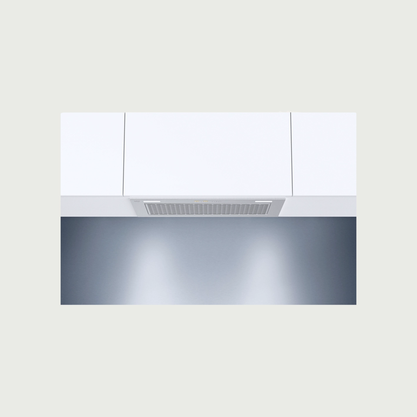 Moderne Dunstabzugshaube in weißer Küche, eingebaut in minimalistische Schränke über glatter Arbeitsplatte.
