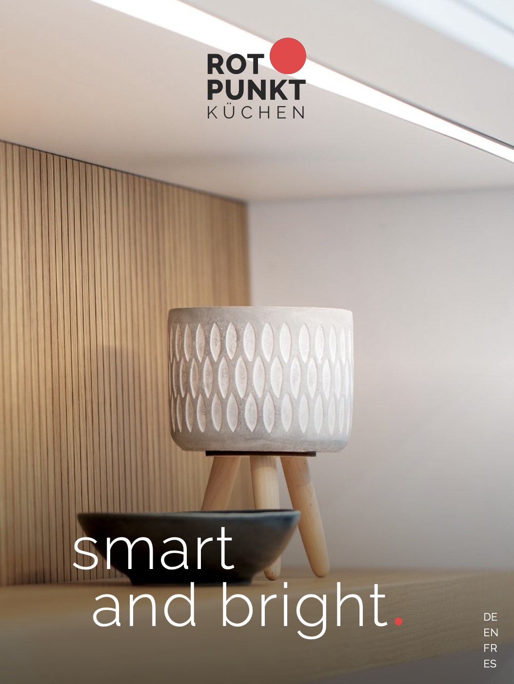 Stilvolle Küchenecke mit modernem Keramikgefäß und dunkler Schale vor hellen Holzpaneelen.