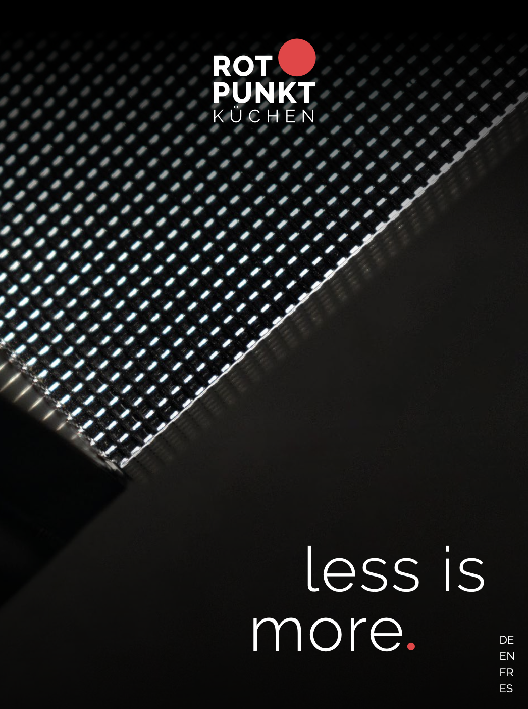 Nahaufnahme einer strukturierten, metallischen Oberfläche mit "ROTPUNKT KÜCHEN" Logo und Slogan.